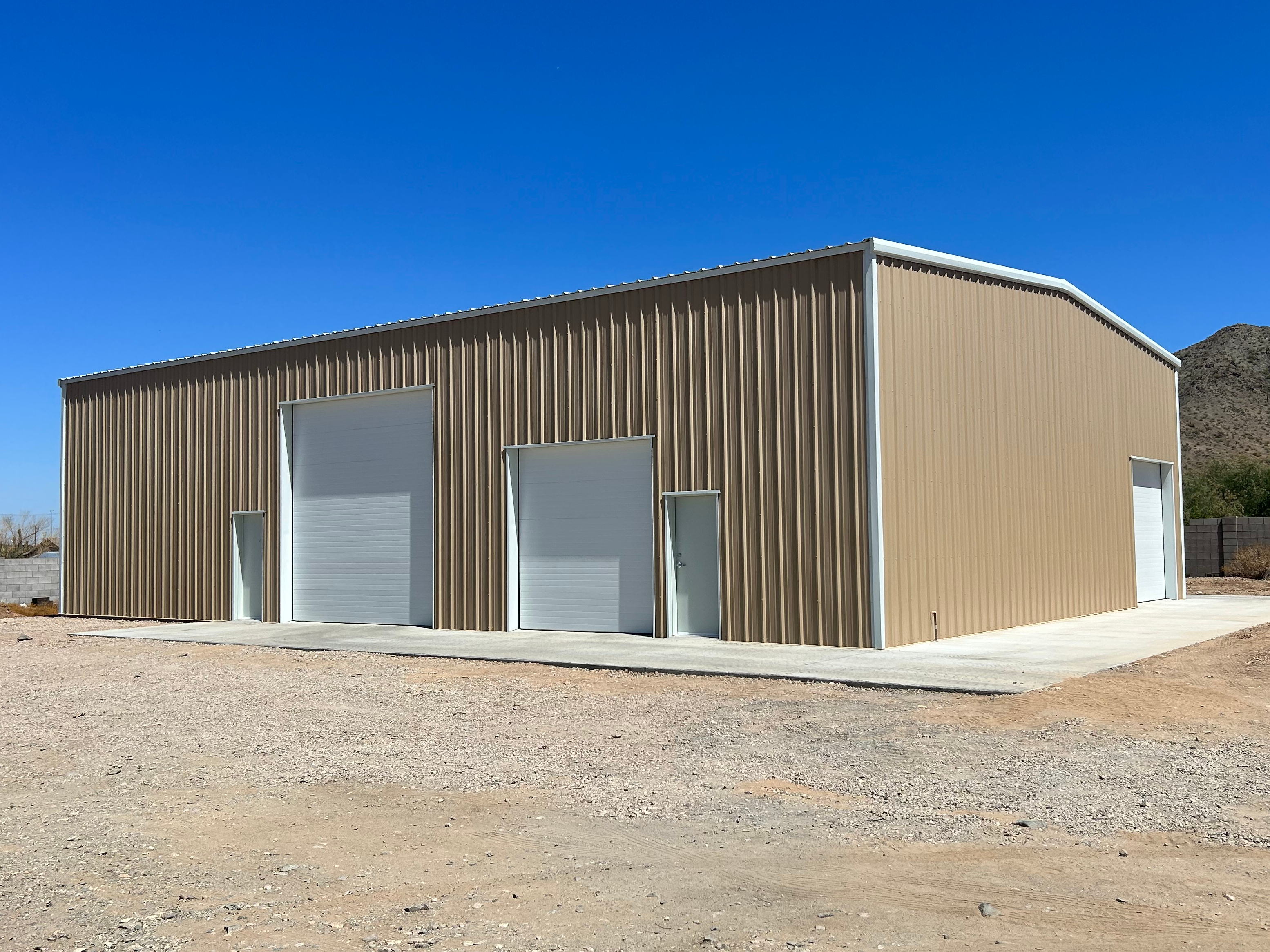 Showing a steel building with many doors of variouos sizes.