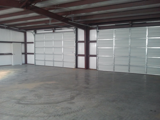 Showing two insulated overhead doors from the interior of a steel building.